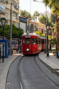 15.06.2023, Antalya, Turkey. Vintage red tram on the streets of Antalya or Istanbul. Retro vintage tram line for tourists and locals leading to the old town centre.