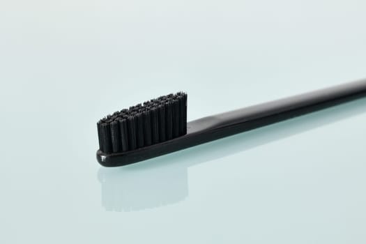 Black Toothbrush on light blue background