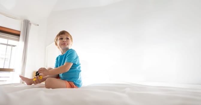 A young boy sitting on top of a bed