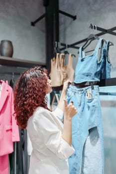 Shopping woman, women's fashion clothes in a store, boutique. Woman choosing clothes in a store.