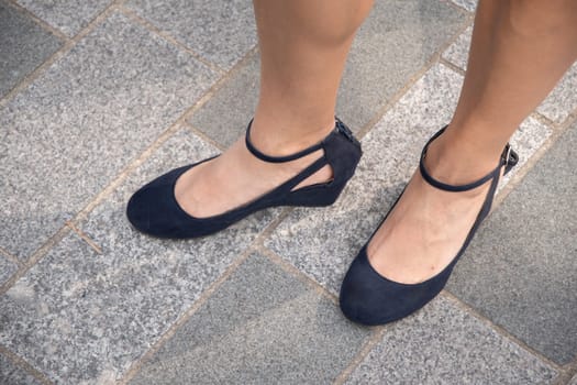 beautiful female tanned legs in dark blue strappy shoes, retro fashion for walking around the city, sexy shoes, High quality photo