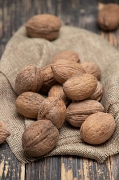 Whole walnuts on a wooden background, top view.