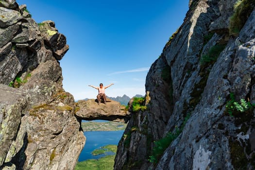 Active Senior tourist woman hiking at the beautiful Rock stuck in mountains Djevelporten. Norway. Happy pensioner climbing a mountain. Scandinavian tourism. Enjoying the outdoor leisure activity lifestyle