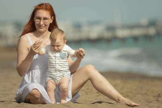 Happy mother and her little son resting on the seaside. Mid shot