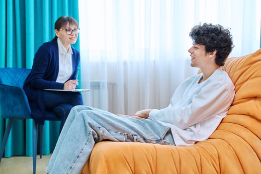 Young guy in therapy session discussing his emotional problems with female psychotherapist. Psychological assistance services, mental health, counseling, support, psychotherapy, psychology concept