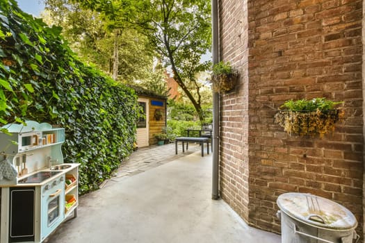 an outdoor kitchen area with brick walls and potted planters on either side of the house, surrounded by lush green foliage