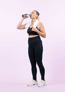 Full body length shot athletic and sporty senior woman drinking water and take a break after exercising on isolated background. Healthy active physique and body care lifestyle after retirement. Clout