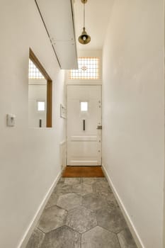 a hallway in a house with white walls and wood trim on the door, light fixture hanging over the doorway