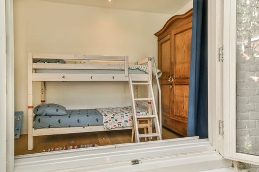 a child's room with bunks in the corner and a window to the right, showing an outside view