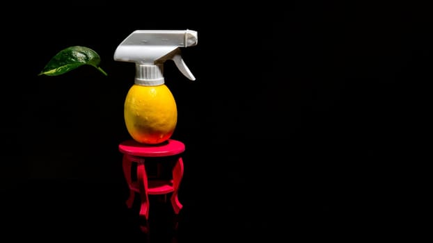 Creative still life with lemon and spray on a black background