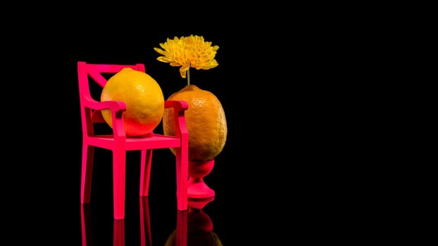 Creative still life with two lemons and pink chair on a black background