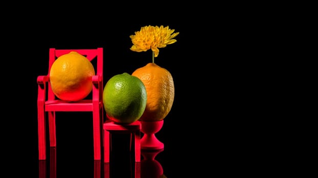 Creative still life with two lemons and lime on a black background. Family portrait.