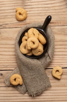 Taralli or tarallini traditional Italian snack in a bowl over an old gray wooden table. Rustic shot of taralli appetizer.