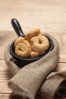 Taralli or tarallini traditional Italian snack in a bowl over an old gray wooden table. Rustic shot of taralli appetizer.