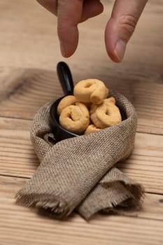 Taralli or tarallini traditional Italian snack in a bowl over an old gray wooden table. Rustic shot of taralli appetizer.