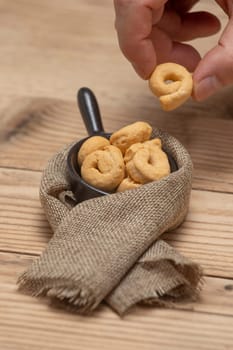 Taralli or tarallini traditional Italian snack in a bowl over an old gray wooden table. Rustic shot of taralli appetizer.