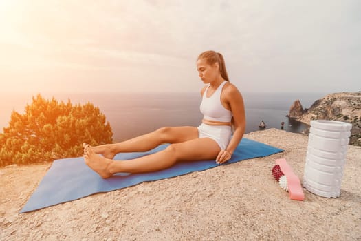 Woman sea pilates. Sporty, middle-aged woman practicing pilates in park near the sea. trains on a yoga mat and exudes a happy and active demeanor, promoting the idea of a healthy lifestyle through exercise and meditation.