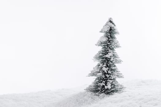 Miniature decorative Christmas tree placed on snow isolated on white