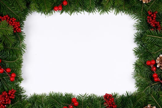 Fir Christmas tree branches and holly berries isolated on white background flat lay top view mock-up