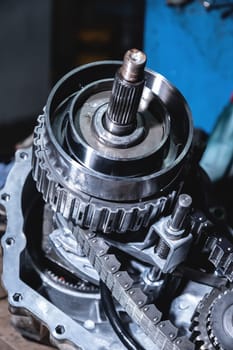 Chain with gears of a disassembled transfer case. Gear synchronization and diagram, transmission detail in a makeshift workshop.