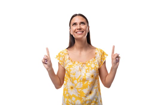 European brunette with flowing hair in a yellow t-shirt smiles with her teeth wide open.