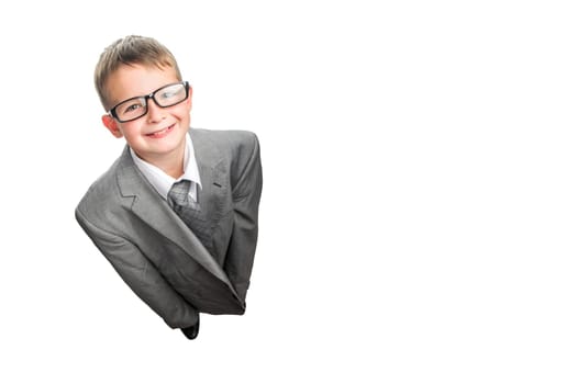 Small child dressed in a business suit and glasses as a businessman, top view. Child in his fathers suit isolated on white background.