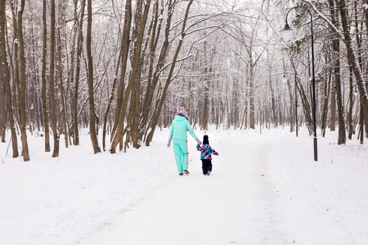 happy family mother and child baby daughter on a winter walk in the woods.