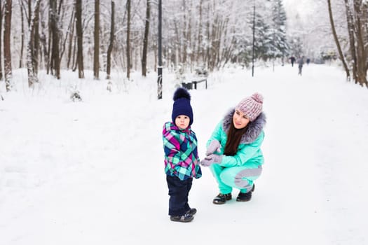 happy family mother and child baby daughter on a winter walk in the woods.