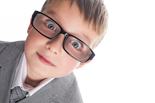 Portrait of a funny child boy wearing glasses against a white background. Smart child in suit and glasses looking at camera. Back to school and education concept.