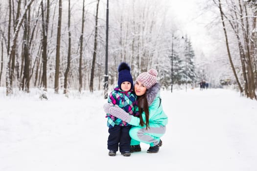 happy family mother and child baby daughter on a winter walk in the woods.