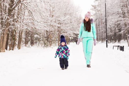 happy family mother and child baby daughter on a winter walk in the woods.