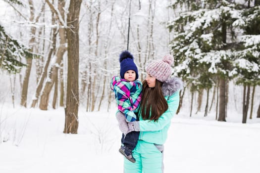 happy family mother and child baby daughter on a winter walk in the woods.