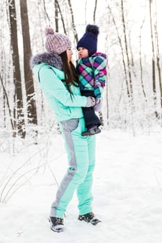 happy family mother and child baby daughter on a winter walk in the woods.