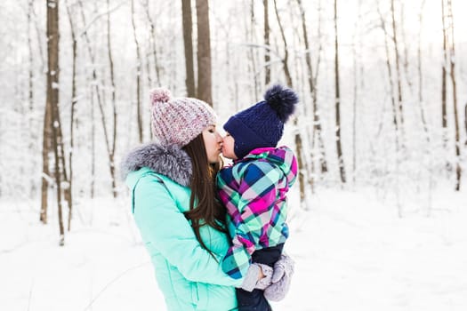 happy family mother and child baby daughter on a winter walk in the woods.