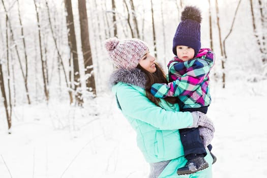 happy family mother and child baby daughter on a winter walk in the woods.