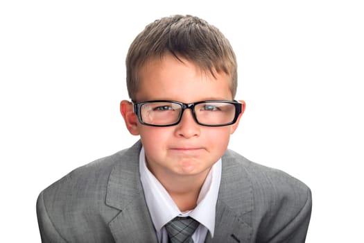 Portrait of a serious child dressed in a business suit and glasses as a businessman. Face of smart boy in glasses and adult suit isolated on white background.