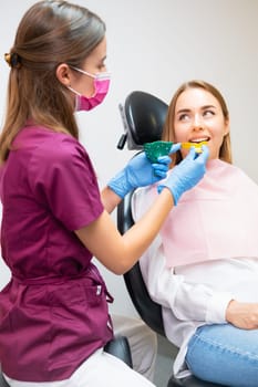 Dentist uses plastic molds to create impressions for orthodontic alignments in the dental office