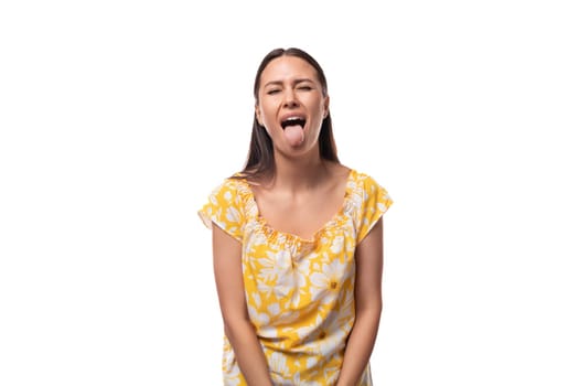 30 year old brunette woman dressed in a summer outfit shows her tongue.