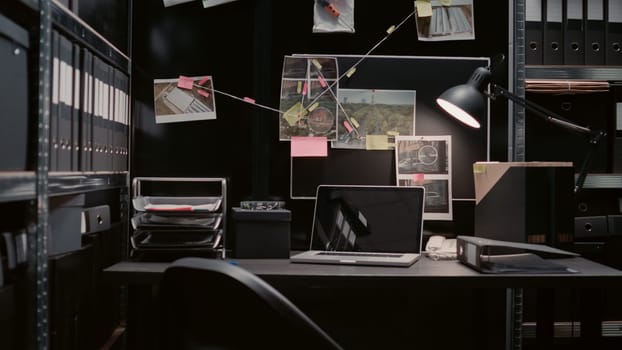 Empty incident room equipped with evidence board and clues on wall map, witness statements papers. Police archive office filled with case files and surveillance footage for investigation.