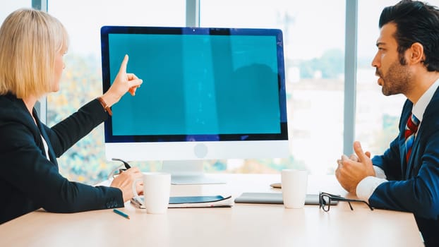 Business people in the conference room with green screen chroma key TV or computer on the office table. Diverse group of businessman and businesswoman in meeting on video conference call . Jivy