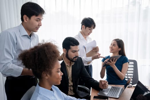 Happy diverse business people work together, discussing in corporate office. Professional and diversity teamwork discuss business plan on desk with laptop. Modern multicultural office worker. Concord