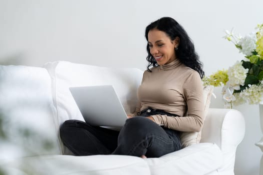 African-American woman using laptop computer for crucial work on internet. Secretary or online content writing working at home.