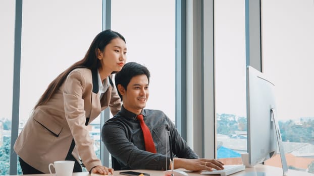 Two business people talk project strategy at office meeting room. Businessman discuss project planning with colleague at modern workplace while having conversation and advice on financial report. Jivy