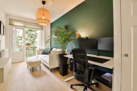 a living room with a desk, chair and computer monitor on the wall in front of the door to the balcony