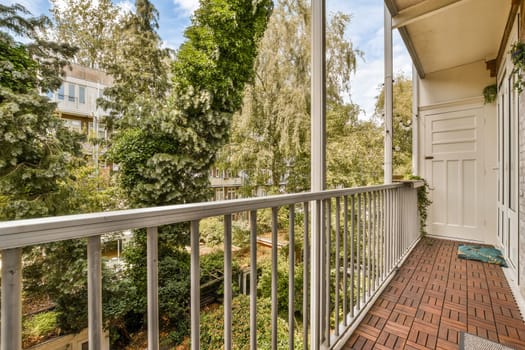 a balcony with trees in the background and a door to another room on the other side of the porch area