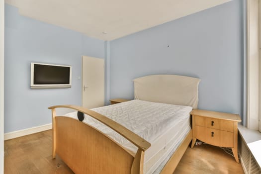 a bedroom with blue walls and hardwood flooring the room has a bed, dresser and tv on the wall