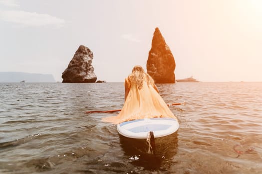 Close up shot of beautiful young caucasian woman with black hair and freckles looking at camera and smiling. Cute woman portrait in a pink bikini posing on a volcanic rock high above the sea