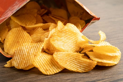 Potato chips, delicious BBQ seasoning spicy for crips, thin slice deep fried snack fast food in open bag.