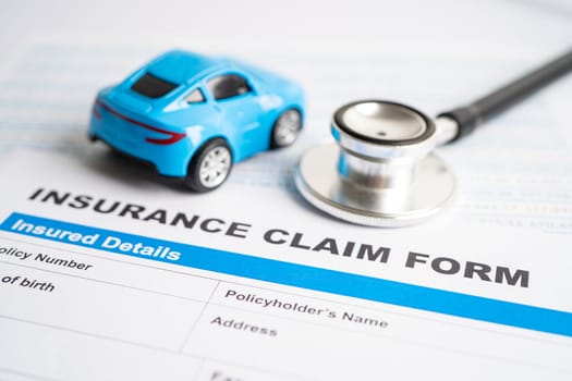 BANGKOK, THAILAND JULY 1, 2022 Stethoscope on Insurance claim accident car form, Car loan, insurance and leasing time concepts.