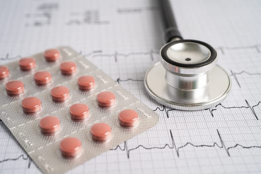 Stethoscope on electrocardiogram ECG with capsule drug, heart wave, heart attack, cardiogram report.